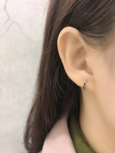 Gros plan de boucles d'oreilles créoles en argent S925 serties de zircons noirs portées