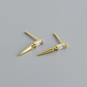 Vue détaillée de boucles d'oreilles dorées avec zircon rectangulaire et pendentif cône