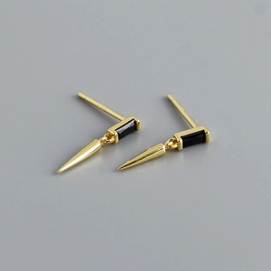 Vue macro d'une boucle d'oreille en argent S925 plaqué or avec zircon noir et charme cône
