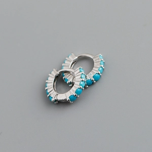 Vue détaillée de créoles en argent S925 avec pierres turquoise et texture métallique