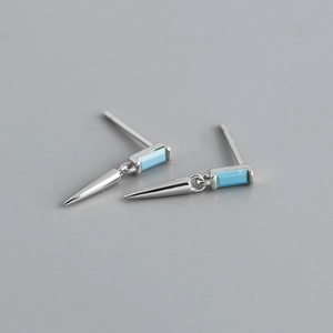 Vue macro de boucles d'oreilles carrées en turquoise argentée avec pendentifs cônes