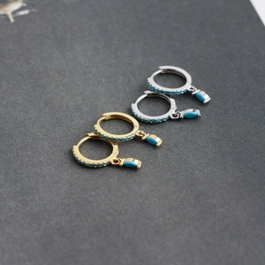 Detail of S925 silver hoop earrings with marquise turquoise stones in gold and silver