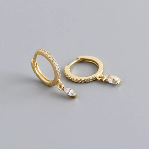 Close-up of golden hoop earrings with marquise cut stones and pave set crystals