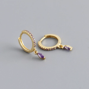 Macro view of gold hoop earrings with purple marquise-cut zircon stones and pavé setting