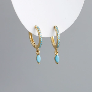 Detailed view of marquise-cut light blue gemstone earrings with golden finish