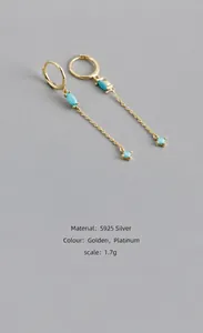 Vista macro degli orecchini a frangia in argento S925 con pietre turchesi oliva oro