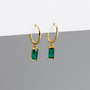 Gros plan du poinçon S925 sur boucles d'oreilles dorées avec zircon vert émeraude