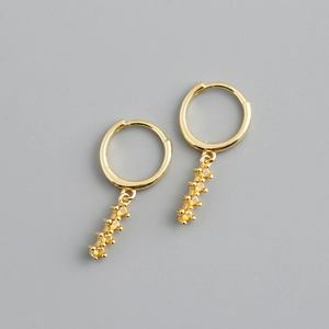 Vue détaillée de boucles d'oreilles dorées avec cinq pierres de zircone jaune éclatantes