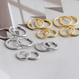 Detail van gehamerde S925 zilveren oorringen in goud en zilver in verschillende maten