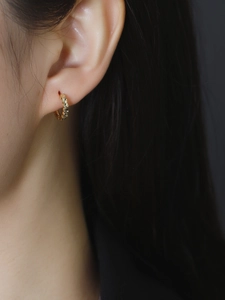 Close-up of S925 sterling silver gold hoop earring with textured diamond cut pattern