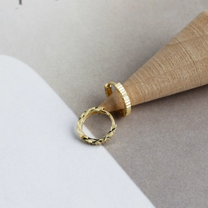 Detalle de pendientes de aro en plata S925 dorada con patrones geométricos de corte diamante