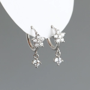 Vue macro de boucles d'oreilles fleur de prunier en argent S925 et zircons blancs
