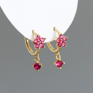 Détail de créoles en argent S925 plaqué or avec zircons roses en forme de fleur