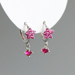 Détail de boucles d'oreilles créoles S925 en argent avec fleurs roses et pendentif carré