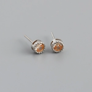 Détail de boucles d'oreilles en zircon orange avec serti perlé en argent sterling
