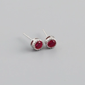 Gros plan de boucles d'oreilles en argent S925 avec zircons rouges en serti couronne