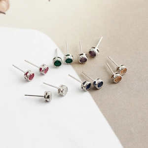 Détail macro de boucles d'oreilles en zircone multicolore avec griffes argentées