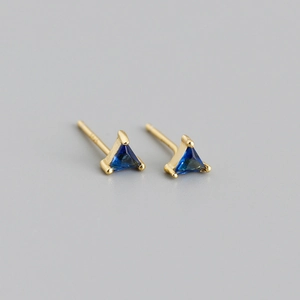 Détail macro de boucles d'oreilles triangle dorées avec zircon bleu et poinçon S925