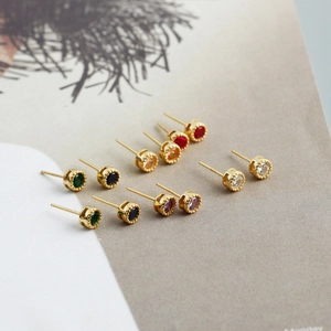 Lot de six boucles d'oreilles rondes en zircon coloré sur un magazine de mode
