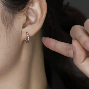 Close-up of S925 sterling silver twisted hoop earring on ear showing the textured rope design