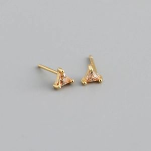 Détail de boucles d'oreilles triangulaires en zircon champagne et monture dorée