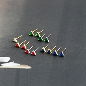 Détails macro des boucles d'oreilles triangle en zircon rouge, vert, bleu et blanc