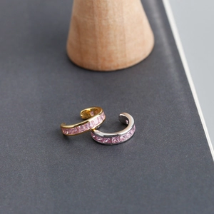 Makroaufnahme von C-förmigen Ear Cuffs mit pinkfarbenen Zirkonias in Kanalfassung