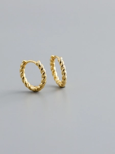 Detailed view of polished gold twist hoop earrings with classic braided rope design
