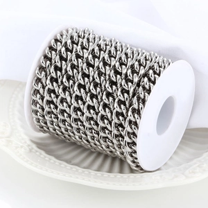 Polished stainless steel Cuban link chain on white plastic spool for jewelry making
