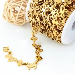 Detail of gold butterfly chain link on white spool for DIY jewelry making and crafts