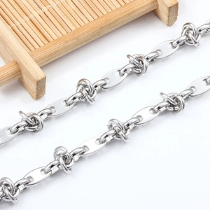 Macro shot of silver stainless steel coffee bean link chain with twisted knot design