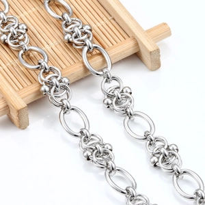 Polished stainless steel chain link necklace with beads on a minimalist bamboo tray