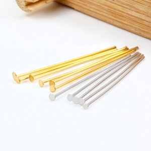 Golden and silver flat head pins for DIY jewelry making on a clean white background