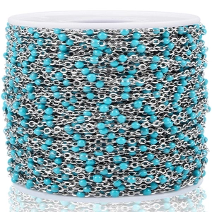 Detalle de cuentas ovales azules en cadena de acero inoxidable en carrete blanco para DIY
