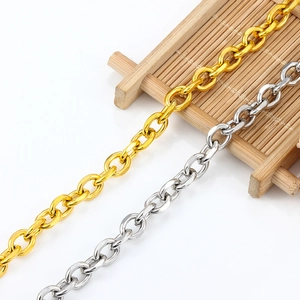 Detalle de cadenas en O de acero inoxidable en oro y plata sobre soporte de bambú