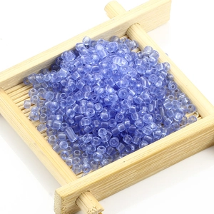 Cuentas cilíndricas azul cielo para joyería DIY en una bandeja de bambú natural