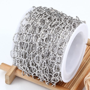 Polished stainless steel curb chain on white spool for DIY jewelry making and crafts