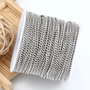Polished silver Cuban link chain on a white spool for DIY jewelry making and crafting