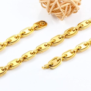 Macro detail of high-polished golden stainless steel coffee bean pig nose chain links