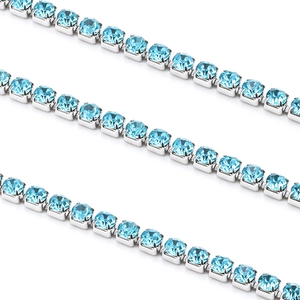 Détail d'une chaîne tennis argentée sertie de zircons bleu clair ronds à 4 griffes