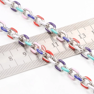 Detail view of colorful oil-dripped stainless steel chain measured with a steel ruler