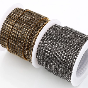 Zwarte strass-klauwkettingen in goud en zilver op witte plastic spoelen