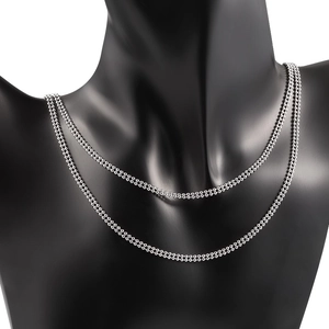 Collar de doble capa con cadena de bolas de acero pulido en un soporte de cuello negro
