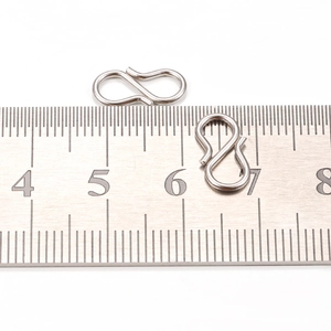 Polished stainless steel S-shape clasp hooks measured with ruler for size comparison
