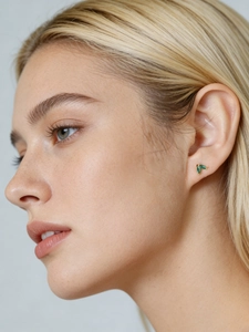 Close-up of elegant gold s925 silver stud earrings with marquise green zircon leaf design