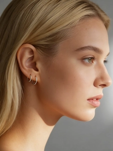 Primer plano de pendientes de aro minimalistas de plata S925 usados por una modelo