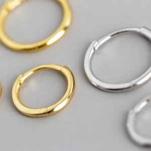 Vista macro de pendientes de aro minimalistas en plata s925 pulida oro y plata