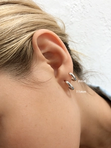 Primer plano de pendientes de aro minimalistas en plata 925 de tamaños 9mm y 11mm