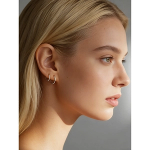 Pendientes de aro minimalistas de plata de ley S925 mostrados de perfil en una modelo