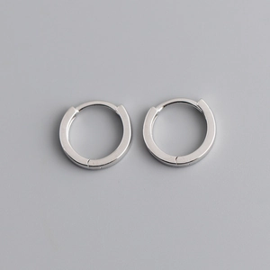 Aros minimalistas de plata de ley S925 pulida presentados sobre un fondo gris claro